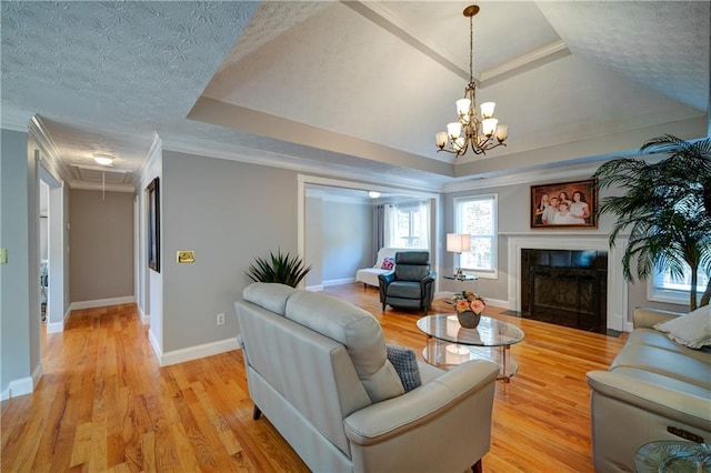 3265 Bethesda Park Ct, Lawrenceville, GA 30044 - living area with attic access, a tile fireplace, light wood finished floors, a chandelier, and crown molding