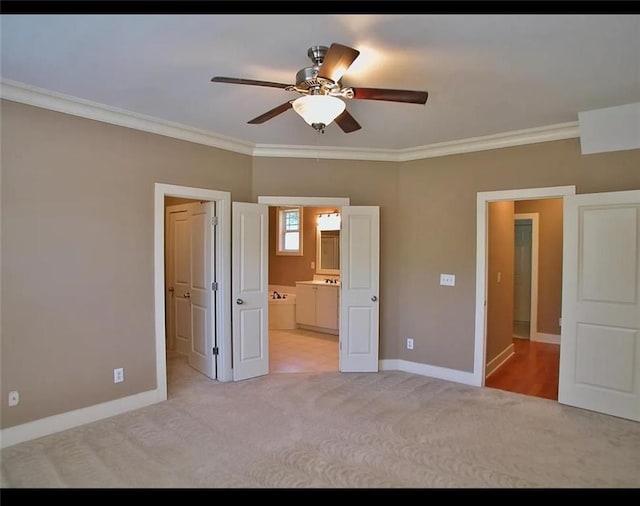 unfurnished bedroom with crown molding, baseboards, light carpet, and ensuite bath