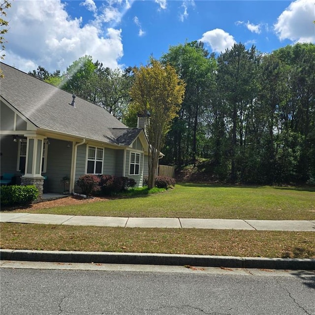 view of property exterior with a lawn and roof with shingles