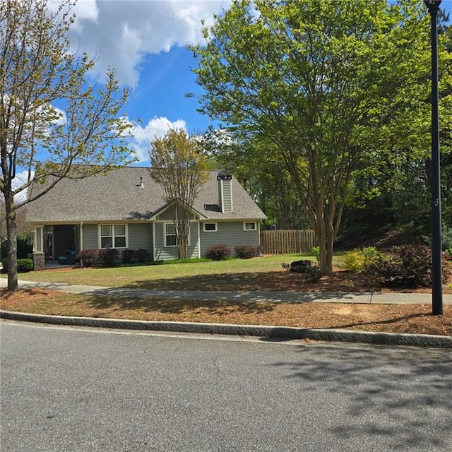 view of front of home with fence and a front lawn
