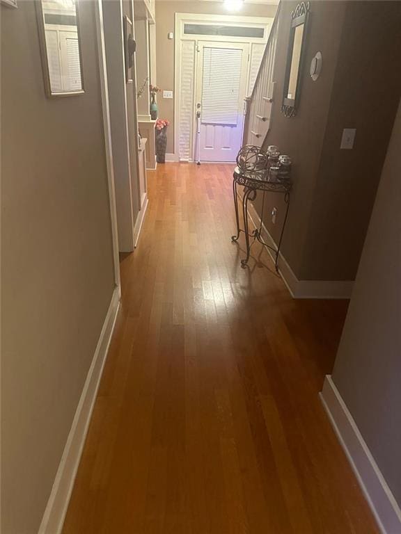 hall with baseboards and hardwood / wood-style flooring