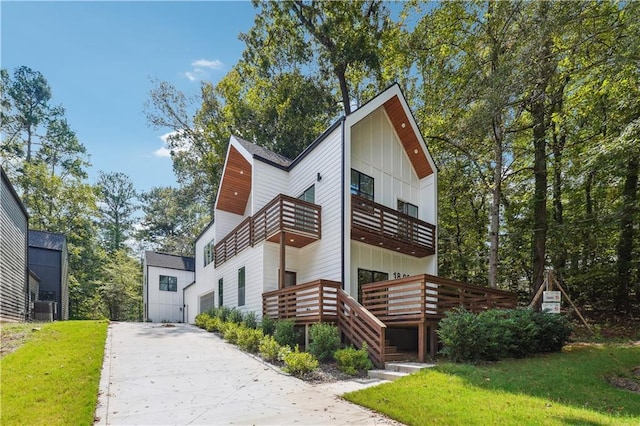 exterior space with central AC, a balcony, and a front yard