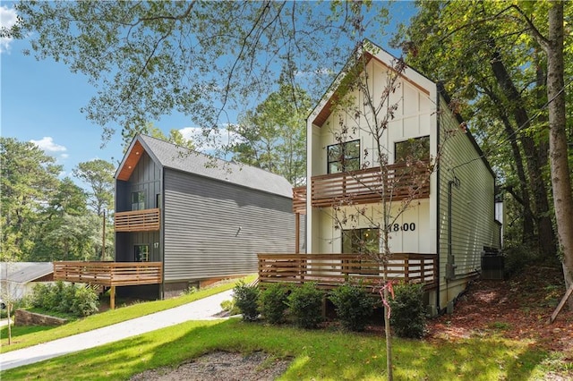 rear view of property featuring a wooden deck and a balcony