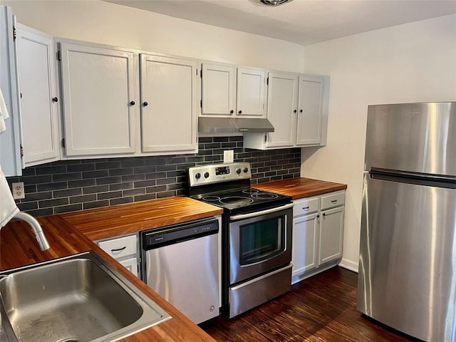 kitchen featuring sink, butcher block countertops, appliances with stainless steel finishes, white cabinets, and backsplash