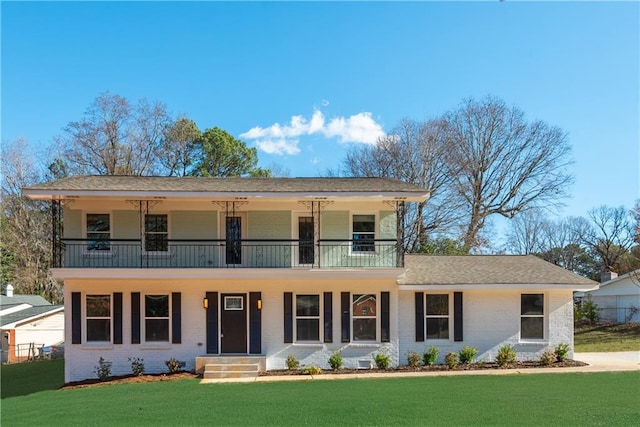 front facade with a balcony and a front lawn