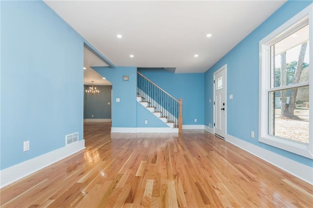 interior space with wood-type flooring, plenty of natural light, and a notable chandelier