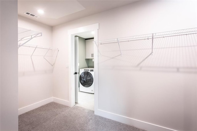 clothes washing area featuring carpet floors, cabinets, and washer / clothes dryer