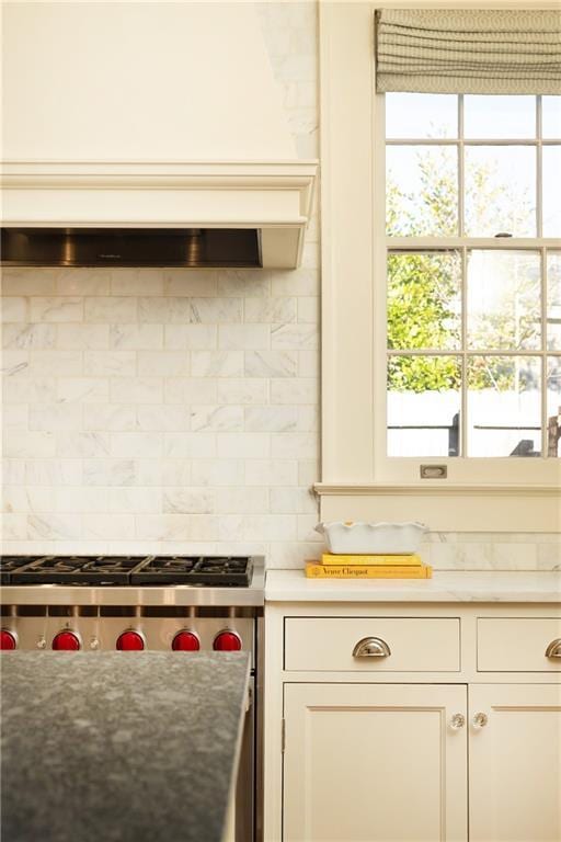 kitchen with tasteful backsplash and white cabinets