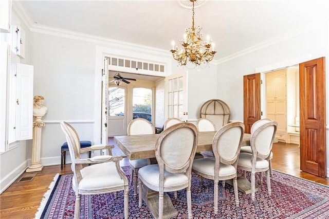 dining space featuring crown molding, wood finished floors, visible vents, and baseboards