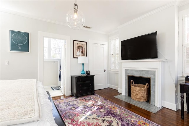 bedroom featuring crown molding, wood finished floors, visible vents, and baseboards