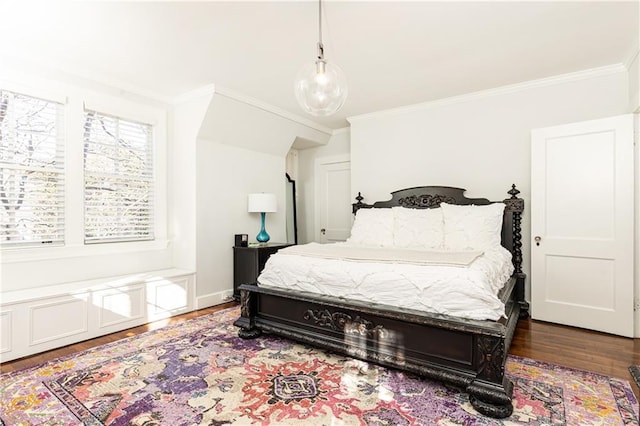 bedroom featuring dark wood finished floors, crown molding, and baseboards