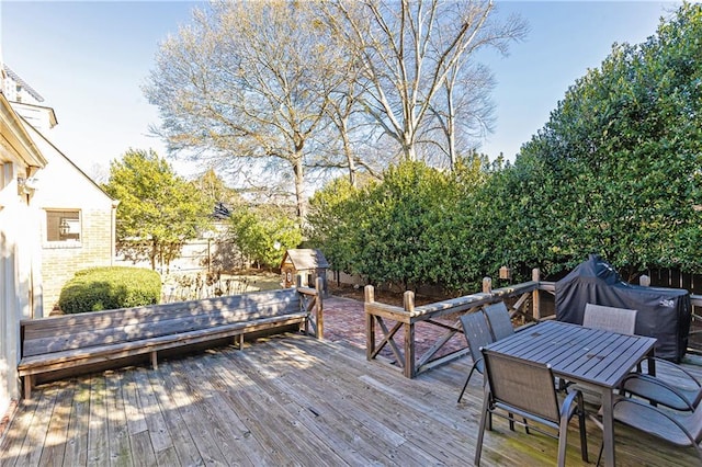 wooden terrace with outdoor dining area and fence