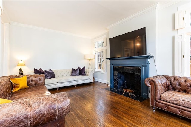 living area with a high end fireplace, crown molding, baseboards, and wood finished floors