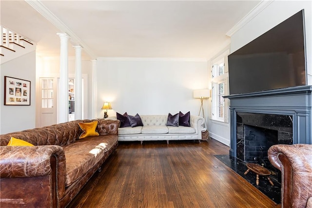 living area with ornamental molding, a fireplace, and wood finished floors