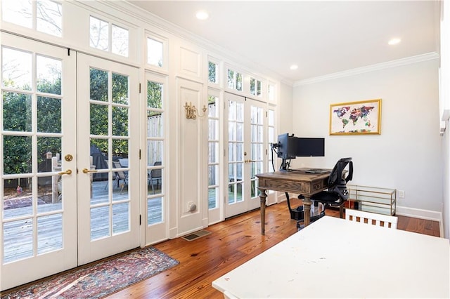 office space featuring wood finished floors, french doors, visible vents, and ornamental molding