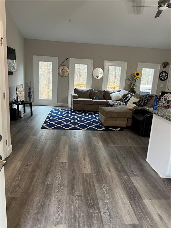 living room featuring dark wood-type flooring, vaulted ceiling, and ceiling fan