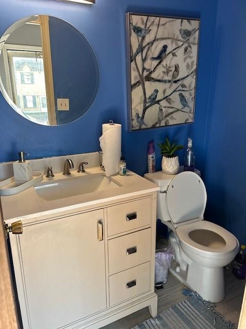 bathroom featuring hardwood / wood-style flooring, vanity, and toilet