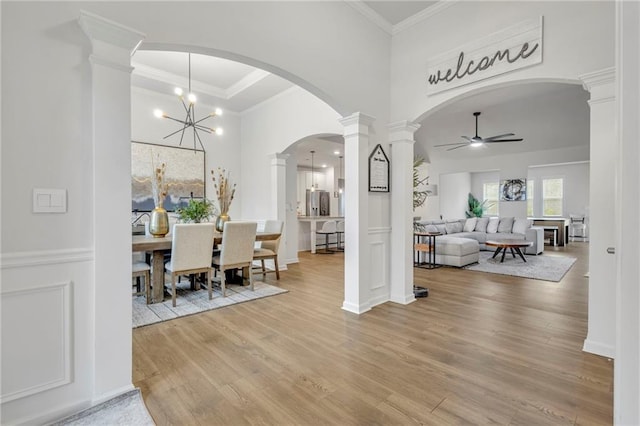 dining area with ornamental molding, decorative columns, light hardwood / wood-style floors, and ceiling fan