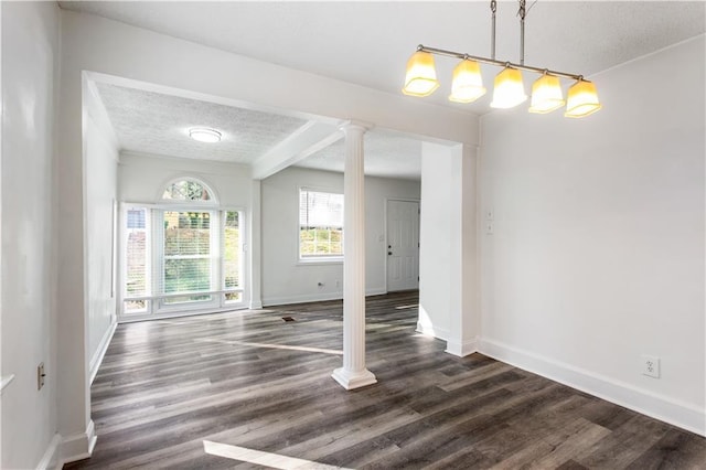 unfurnished dining area featuring a textured ceiling, ornate columns, and dark hardwood / wood-style flooring