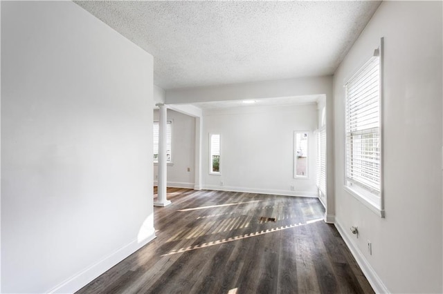 1380 Westmont Rd SW, Atlanta, GA 30311 - unfurnished living room with decorative columns, a textured ceiling, baseboards, and wood finished floors