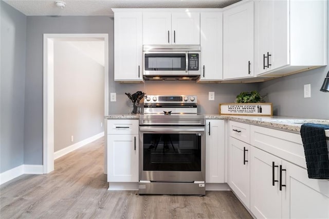 1912 Wax Rd, Aragon, GA 30113 - kitchen with stainless steel appliances, light wood finished floors, white cabinets, and baseboards