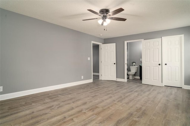 1912 Wax Rd, Aragon, GA 30113 - unfurnished bedroom featuring baseboards, wood finished floors, a textured ceiling, and ensuite bath
