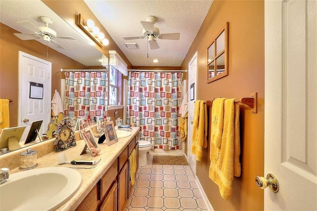 bathroom with tile flooring, ceiling fan, toilet, and a textured ceiling