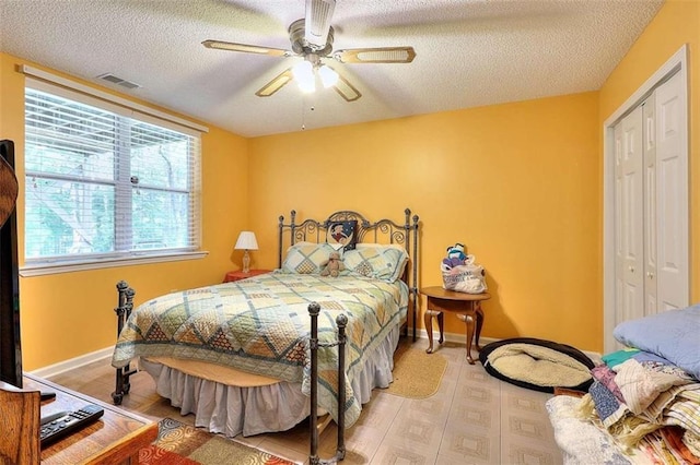 bedroom featuring a textured ceiling, a closet, wood-type flooring, and ceiling fan