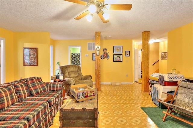 living room featuring ceiling fan and a textured ceiling