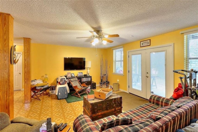 living room with a healthy amount of sunlight, a textured ceiling, ceiling fan, and french doors