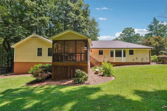 rear view of property featuring a sunroom and a lawn