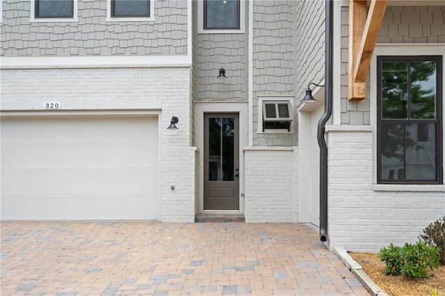 entrance to property with a garage and a wall unit AC