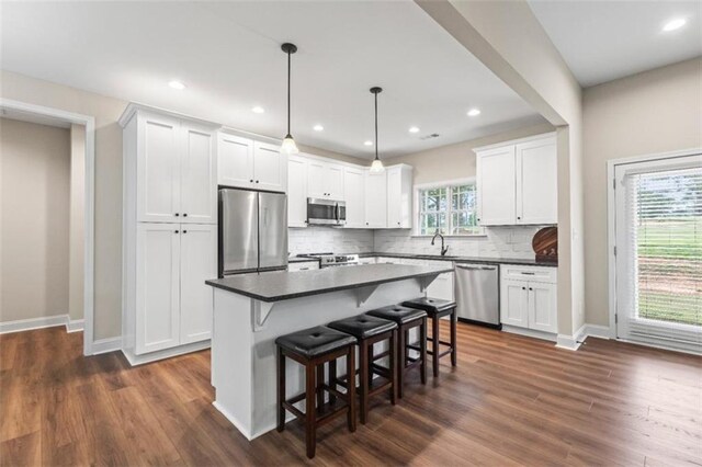 kitchen featuring a sink, appliances with stainless steel finishes, tasteful backsplash, and white cabinetry