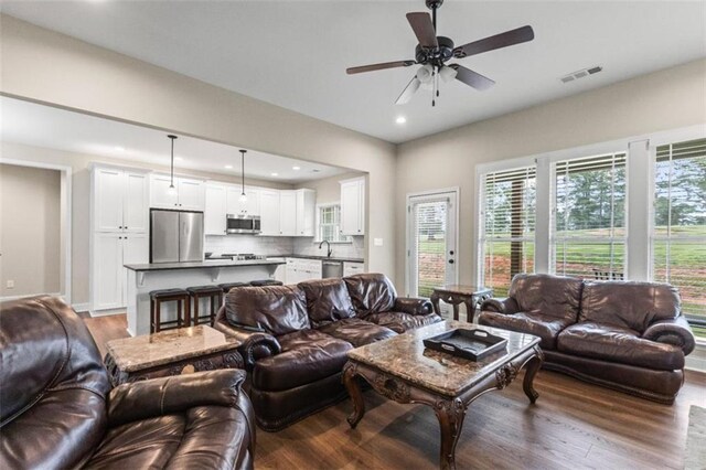 living room featuring recessed lighting, a ceiling fan, visible vents, and wood finished floors