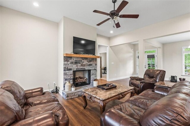 living area featuring ceiling fan, a fireplace, wood finished floors, baseboards, and recessed lighting
