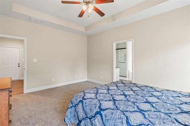 carpeted bedroom with a ceiling fan, baseboards, visible vents, and ensuite bathroom
