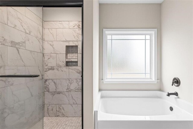 bathroom with a shower stall and a garden tub