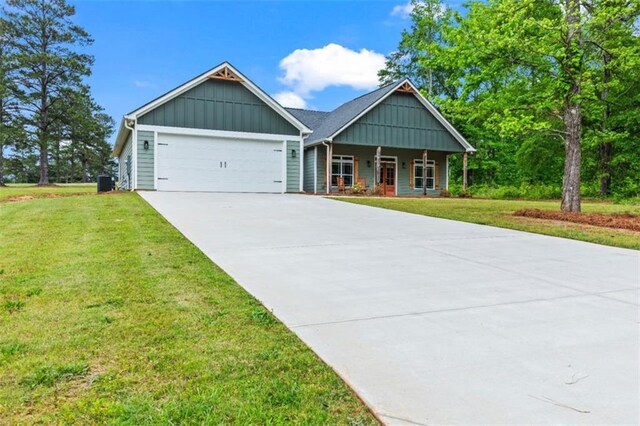 craftsman inspired home featuring covered porch, a front yard, board and batten siding, an attached garage, and driveway