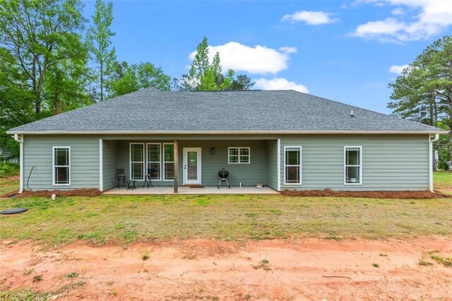 back of property with a patio and a yard