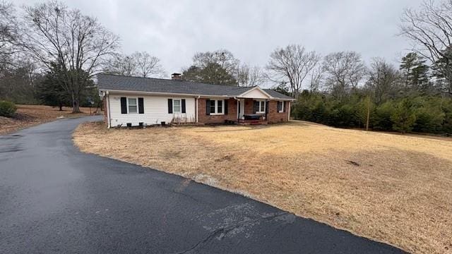 single story home with driveway and a front yard