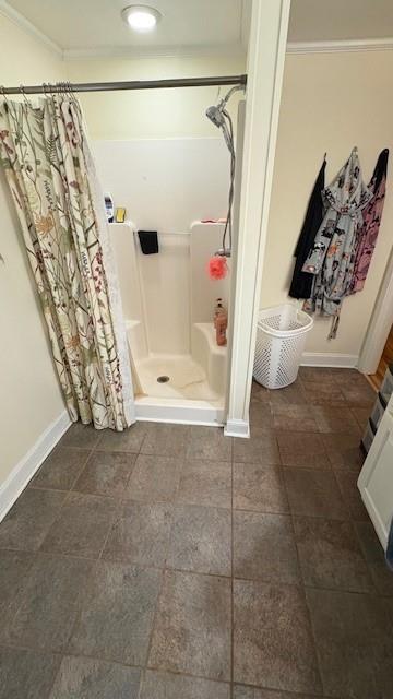 full bath featuring a shower stall and baseboards