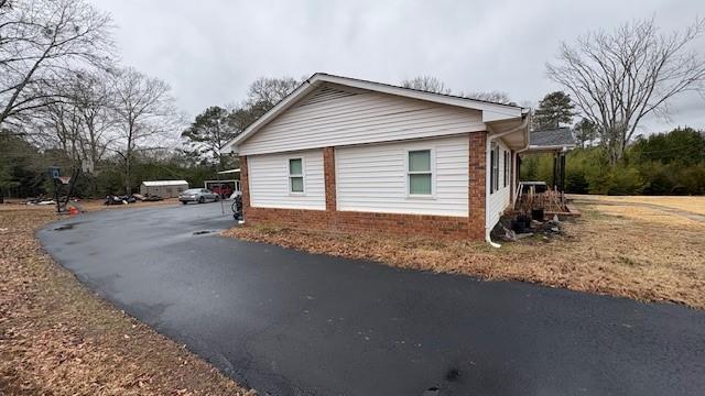 view of side of property with driveway and brick siding