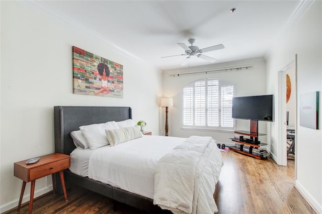 bedroom featuring ornamental molding, a ceiling fan, baseboards, and wood finished floors