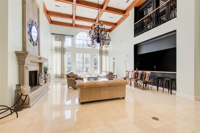 tiled living area featuring a fireplace with raised hearth, a notable chandelier, coffered ceiling, a towering ceiling, and beamed ceiling