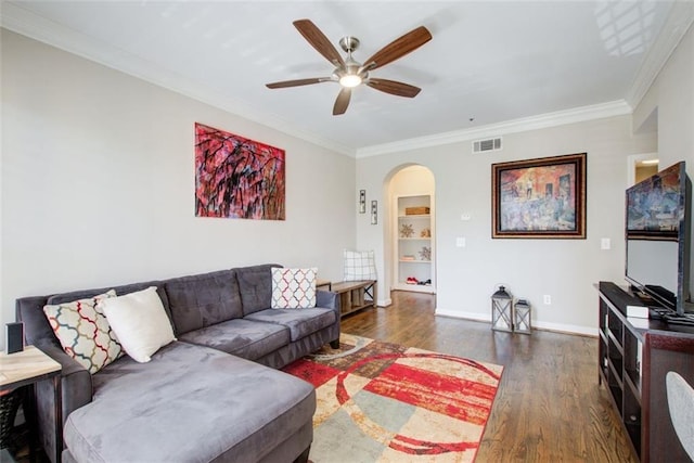 living room featuring arched walkways, visible vents, crown molding, and wood finished floors