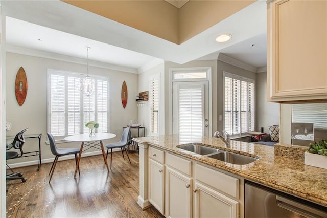 kitchen with dishwasher, wood finished floors, a sink, crown molding, and a notable chandelier