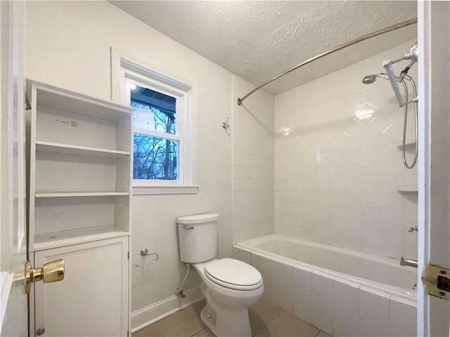 bathroom featuring toilet, tiled shower / bath combo, tile patterned flooring, and a textured ceiling