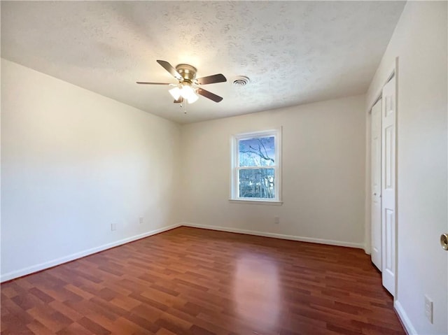 unfurnished bedroom with ceiling fan, dark hardwood / wood-style floors, and a textured ceiling