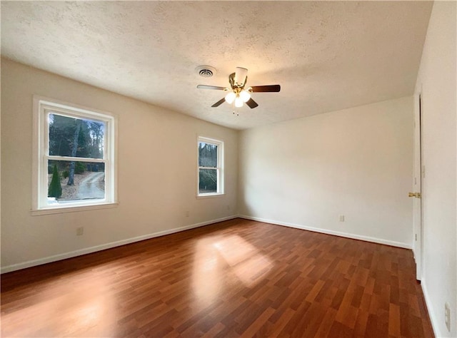 unfurnished room featuring ceiling fan, dark hardwood / wood-style floors, and a textured ceiling