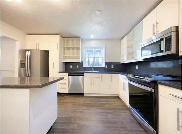 kitchen with tasteful backsplash, white cabinetry, appliances with stainless steel finishes, and sink